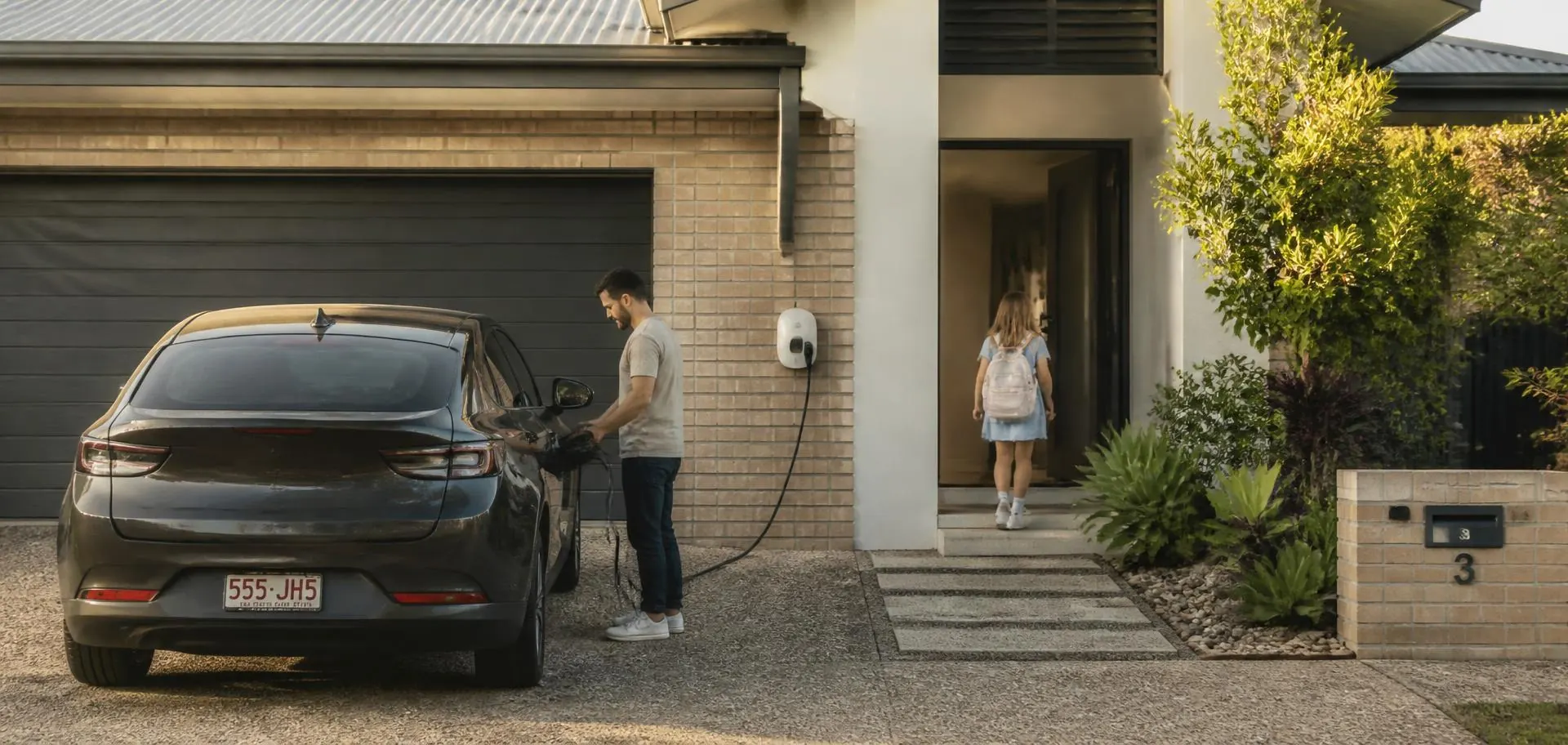 Family arriving home at an Adelaide house in the late afternoon and plugging in their electric car